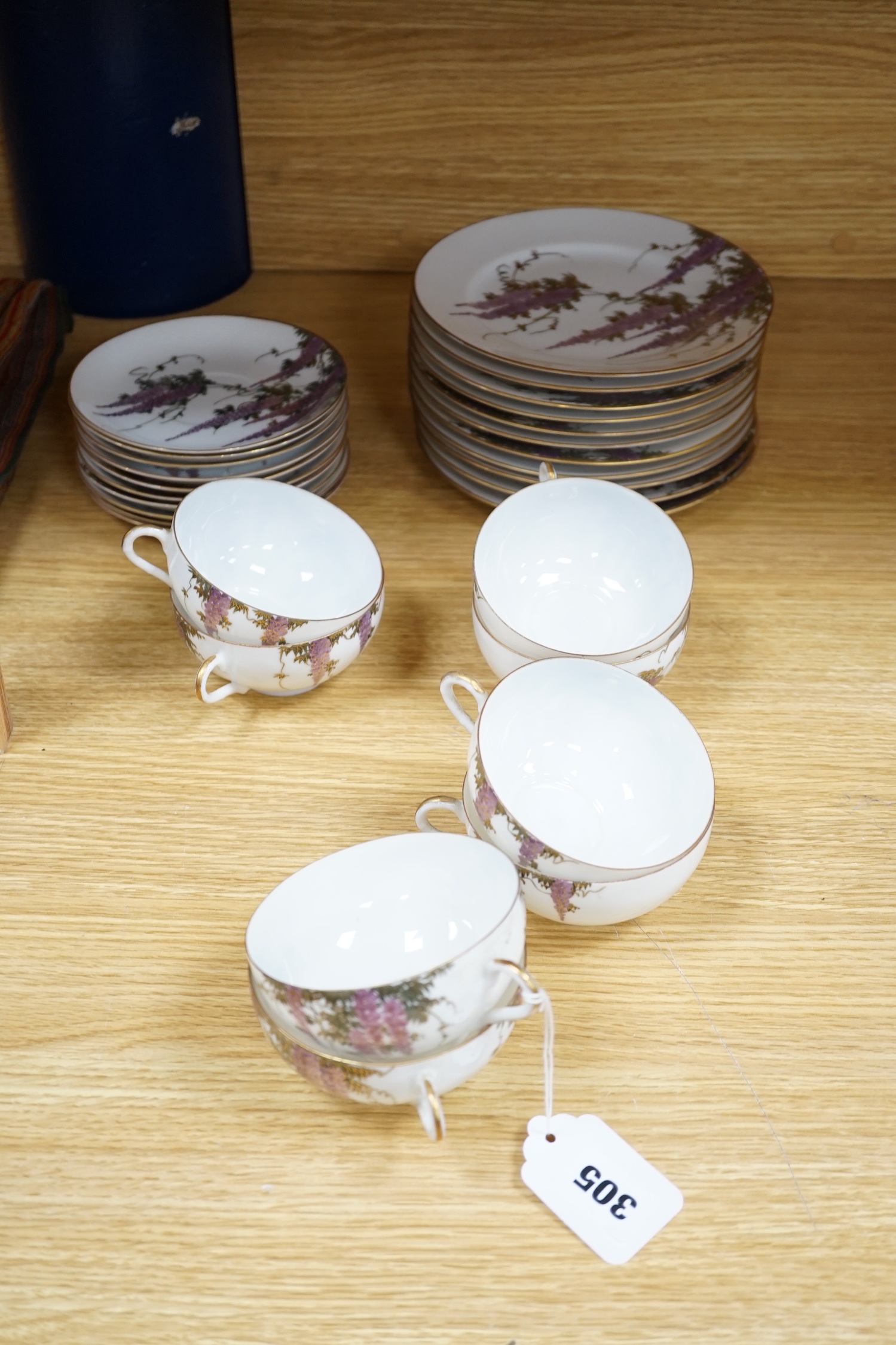 A Japanese part tea service with wisteria decoration, comprising of eight cups, eleven saucers and twelve tea plates